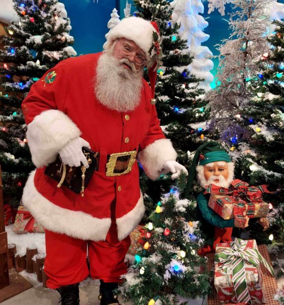 Santa Claus holding a pipe in a festive Christmas setting.