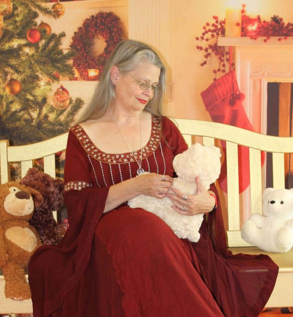 A woman in a red dress holding a baby on a crib.